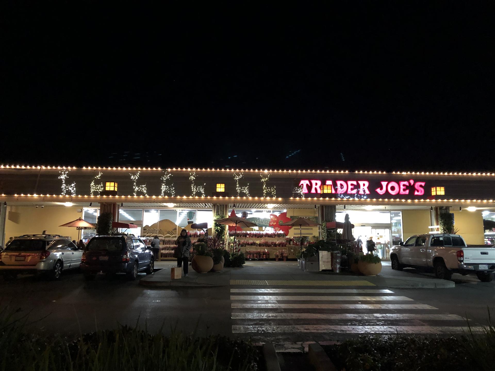 A trader joe 's store is lit up at night