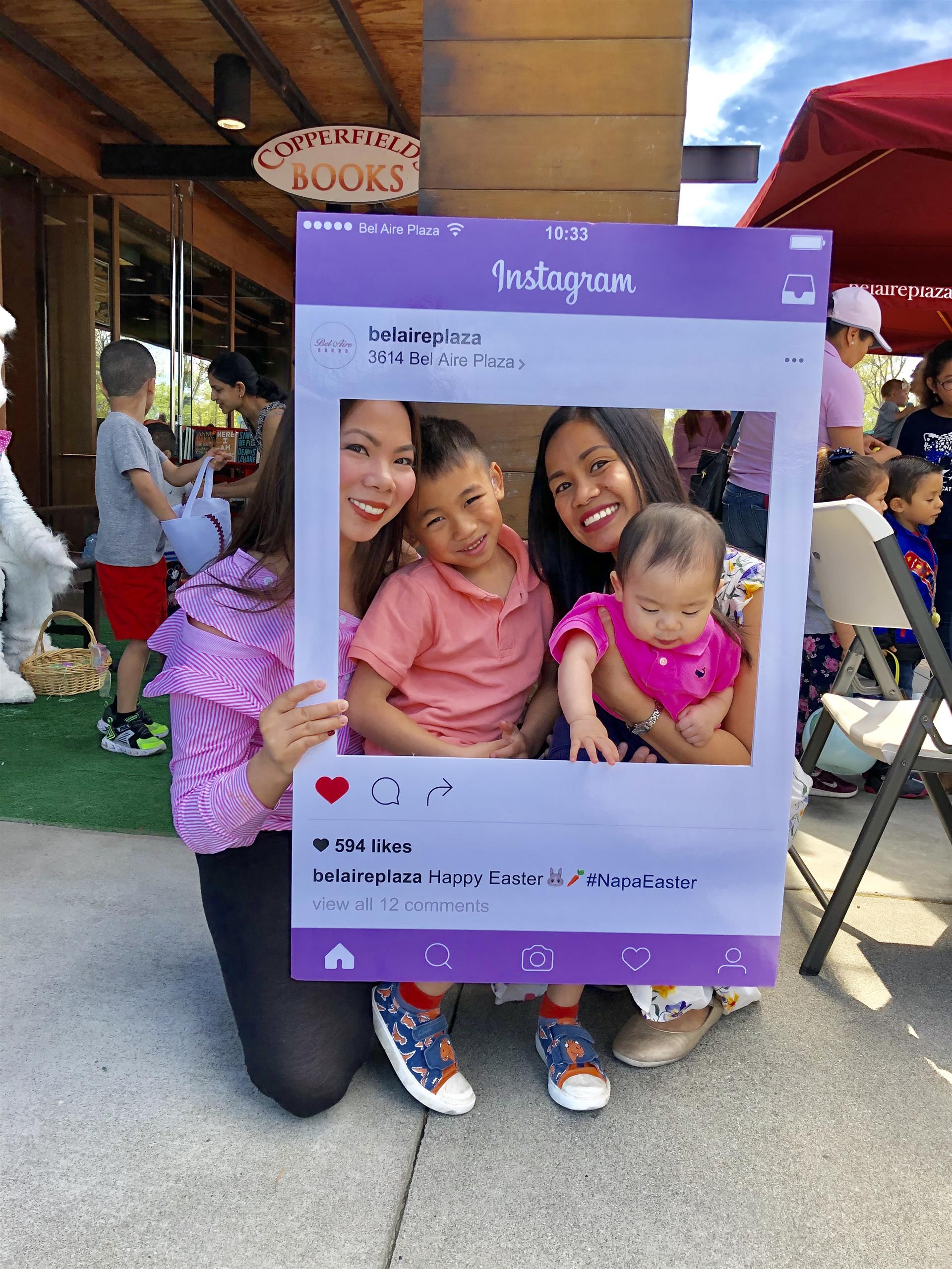 A woman is holding a picture frame with a picture of a family in it.