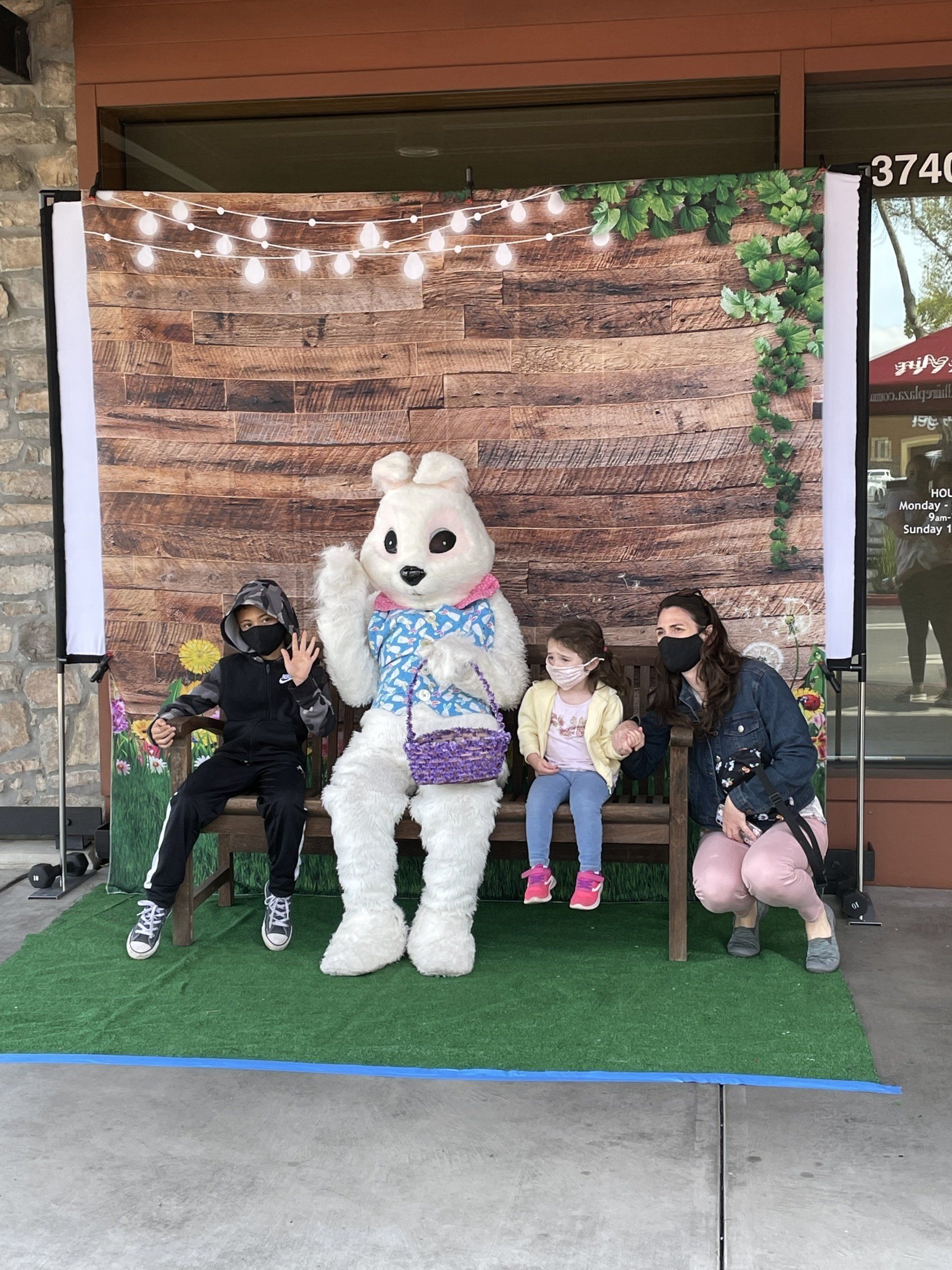 A woman and two children are posing for a picture with an easter bunny.