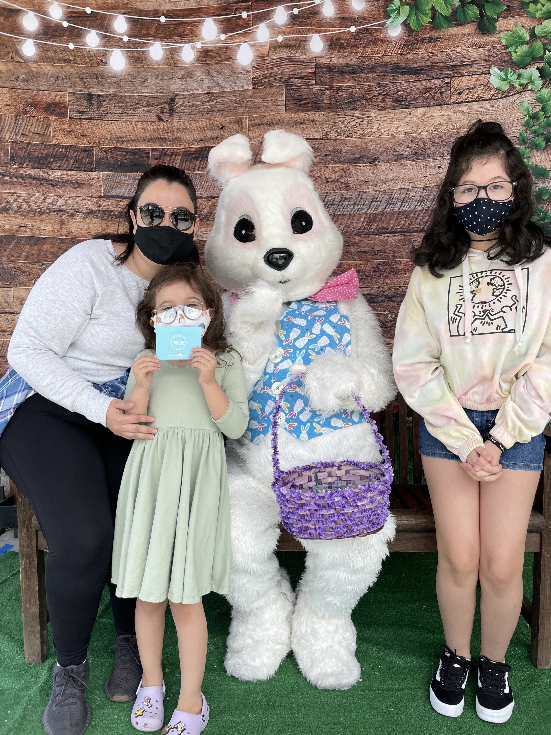 A woman and two children are posing for a picture with an easter bunny.