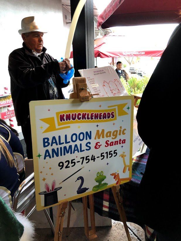 A sign that says balloon magic animals and santa on it