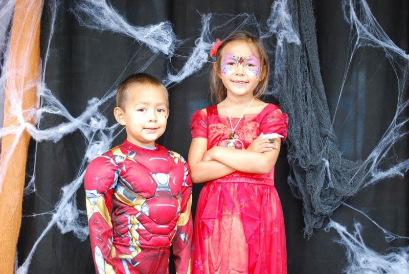 A boy and a girl in costumes are posing for a picture.