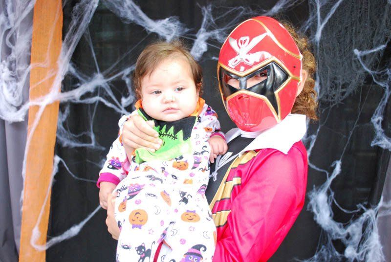 A woman in a pirate costume is holding a baby