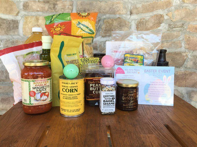 A wooden table topped with a variety of food items including a can of corn