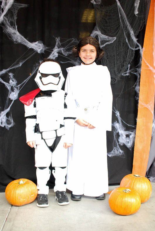 A girl dressed as princess leia and a stormtrooper pose for a picture.
