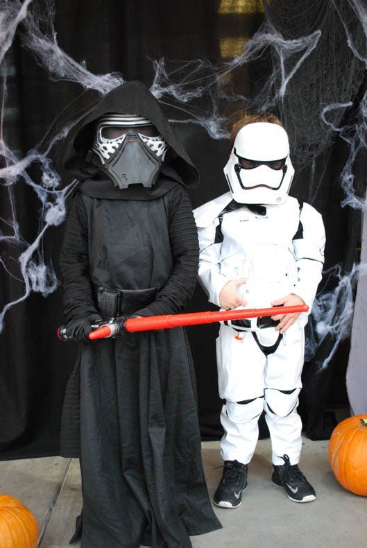 Two children in star wars costumes are standing next to each other.