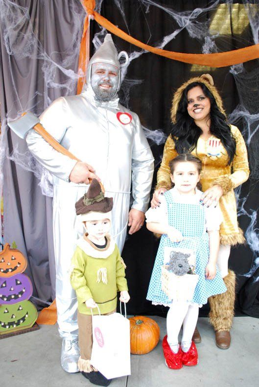 A family dressed in costumes for halloween is posing for a picture.