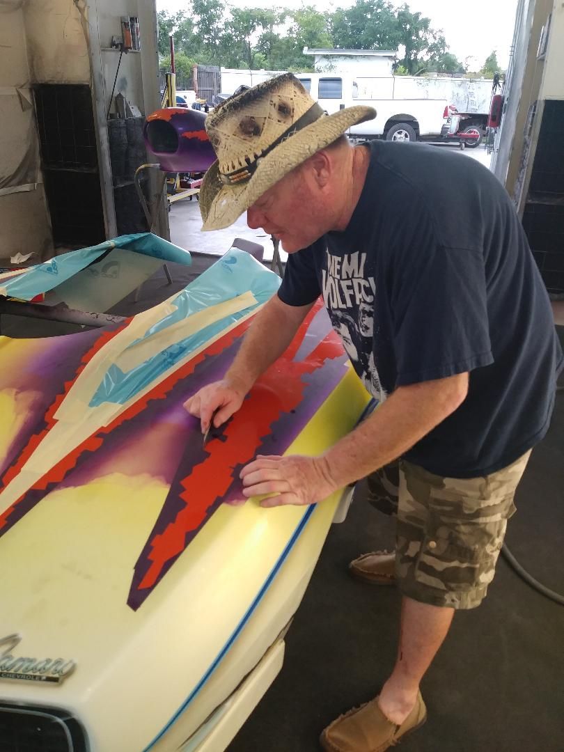 A man wearing a hat and a shirt that says team makers