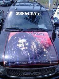 A black gmc truck with a zombie hood wrap.
