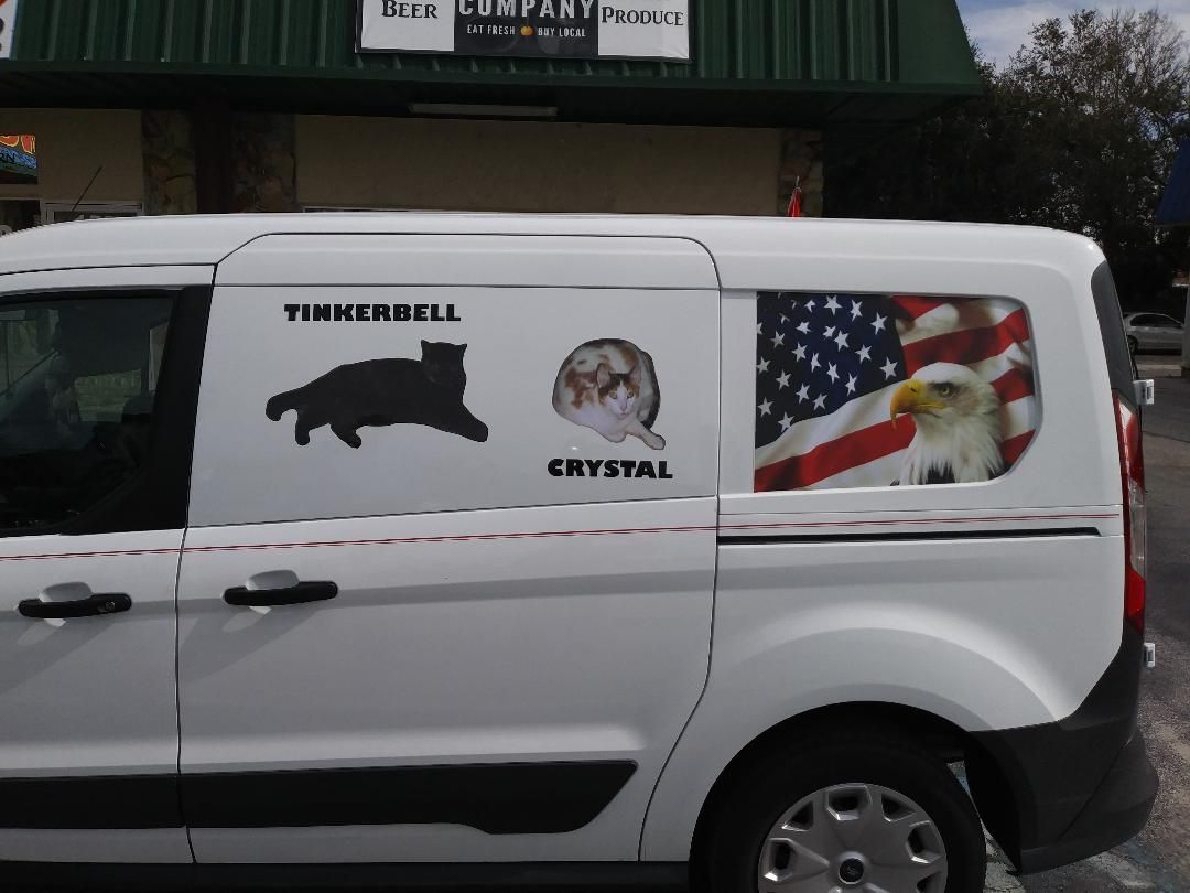 A white van with a cat and an eagle on the side