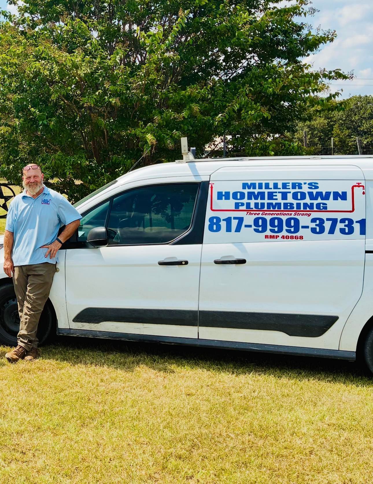 Man stands by Miller's Hometown Plumbing van, wearing a blue shirt and khaki pants.