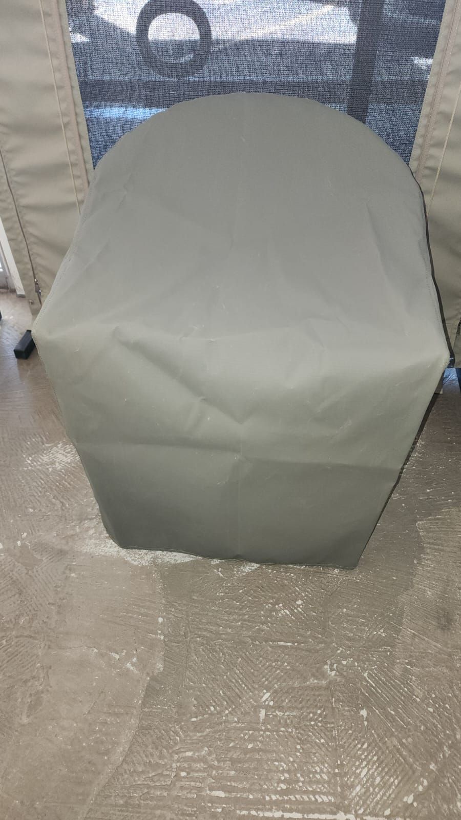 A chair with a cover on it is sitting in front of a tent.