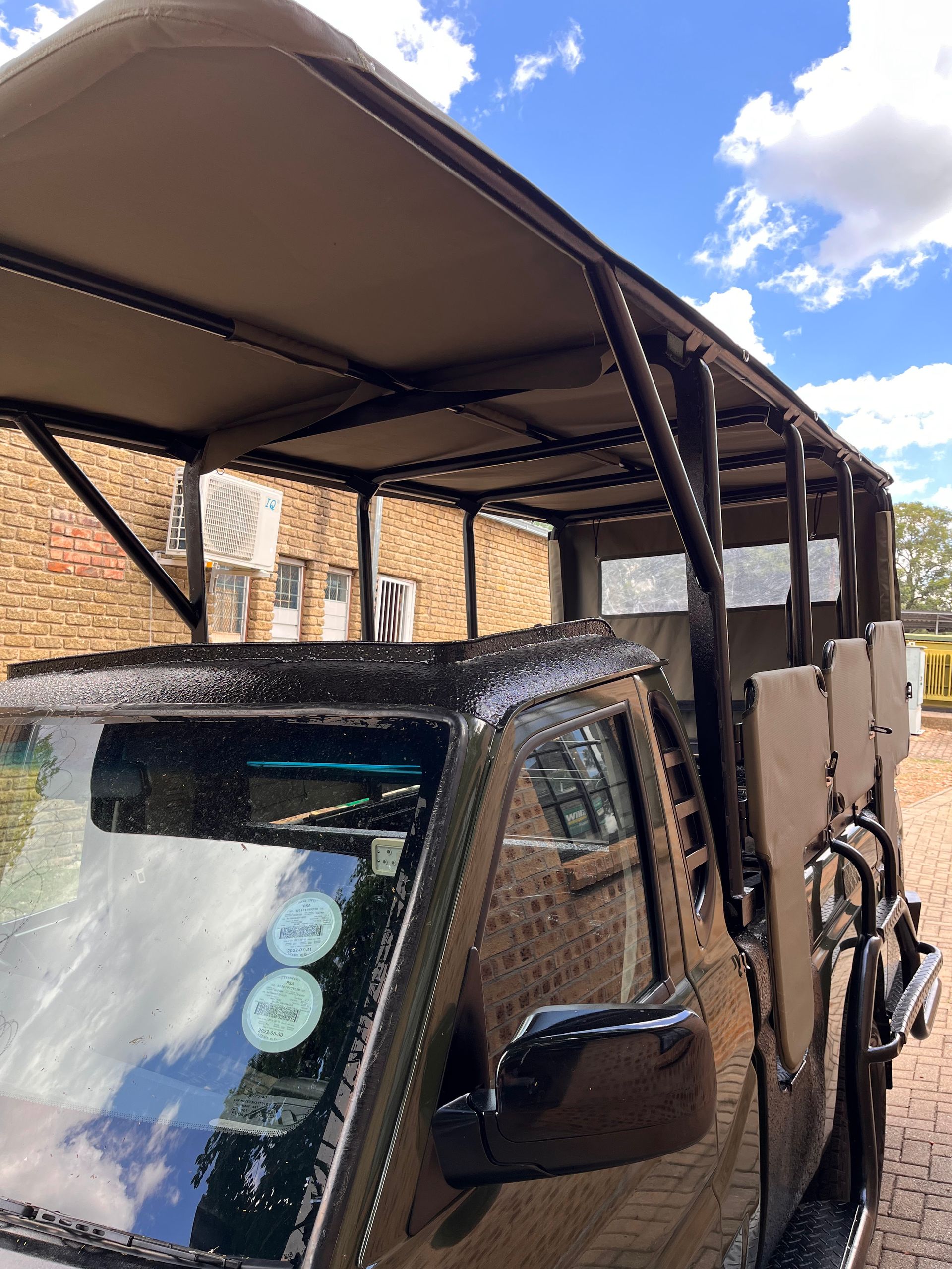 A truck with a canopy on top of it is parked in front of a building.