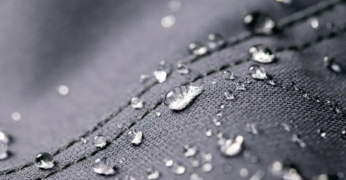 A close up of water drops on a piece of fabric.