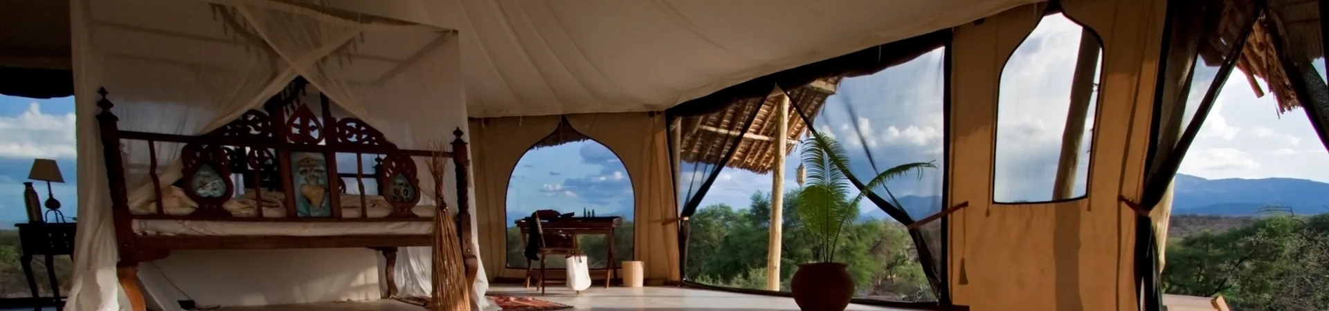 A room with a canopy bed and a view of the mountains.