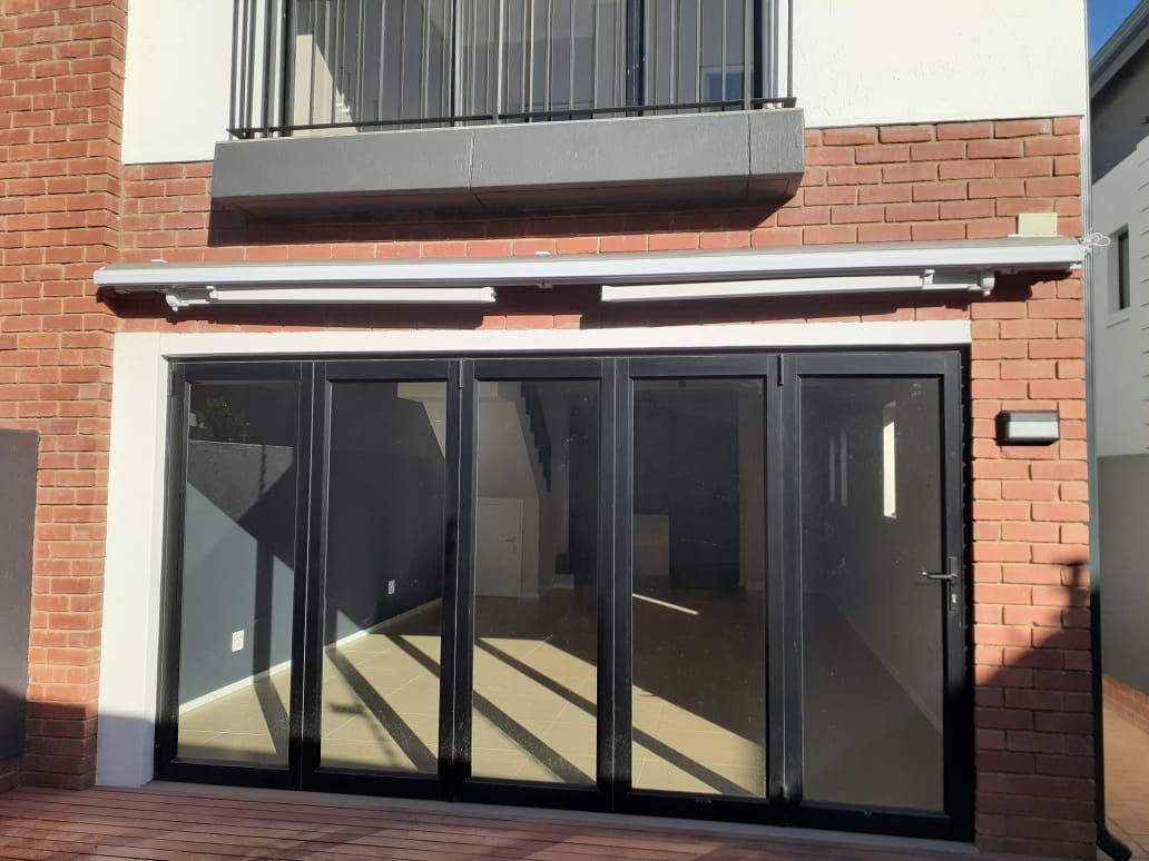 A brick building with a balcony and sliding glass doors