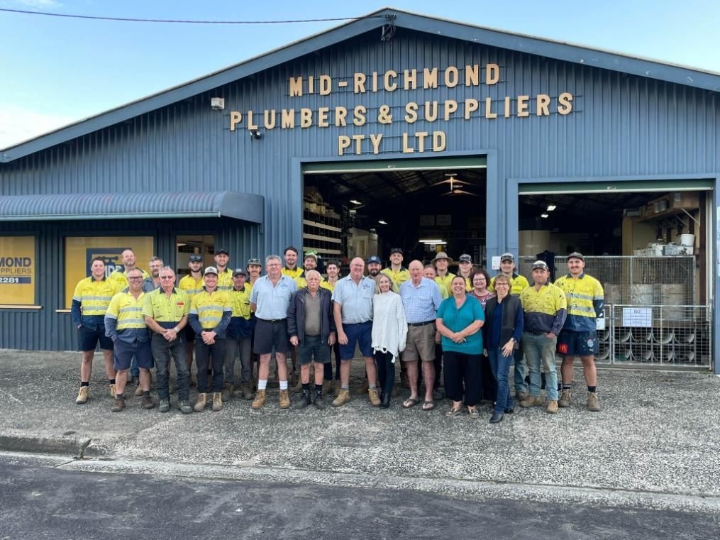 A Group of People Standing Outside a Building — Mid Richmond Plumbers & Suppliers in Maclean, NSW