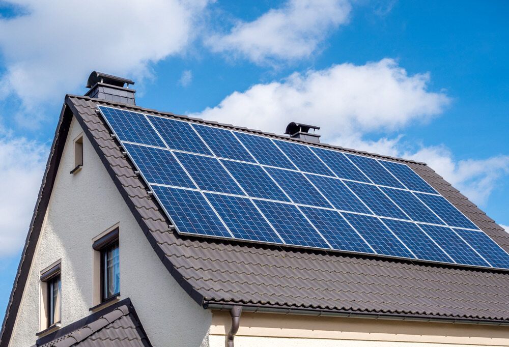 House With Solar Panels on the Roof Against a Partly Cloudy Blue Sky — Mid Richmond Plumbers & Suppliers in Coraki, NSW