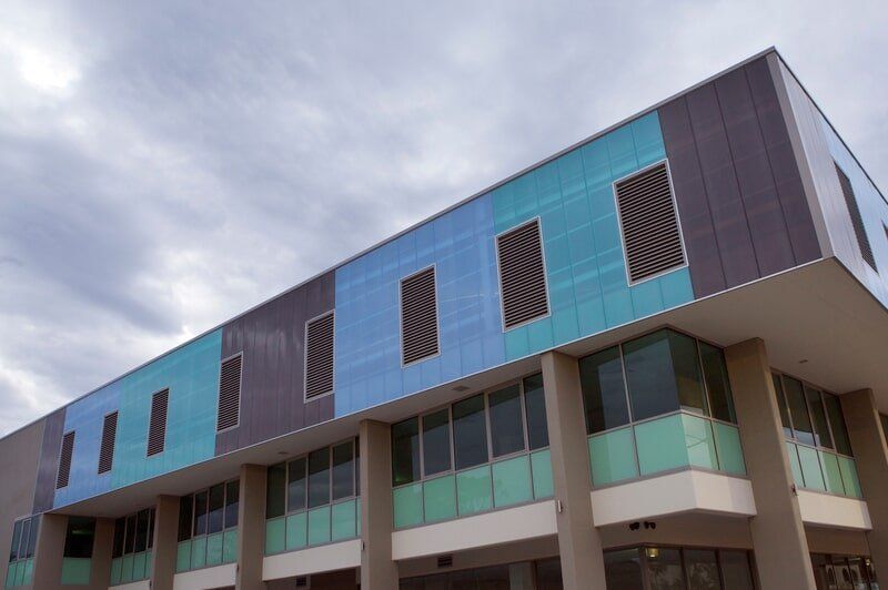 A Large Building With a Lot of Windows and a Cloudy Sky in the Background — Mid Richmond Plumbers & Suppliers in Coraki, NSW