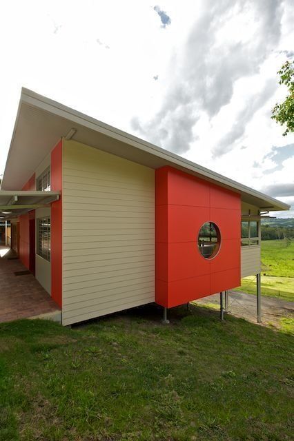 A Red and White House With a Round Window on the Side — Mid Richmond Plumbers & Suppliers in Coraki, NSW