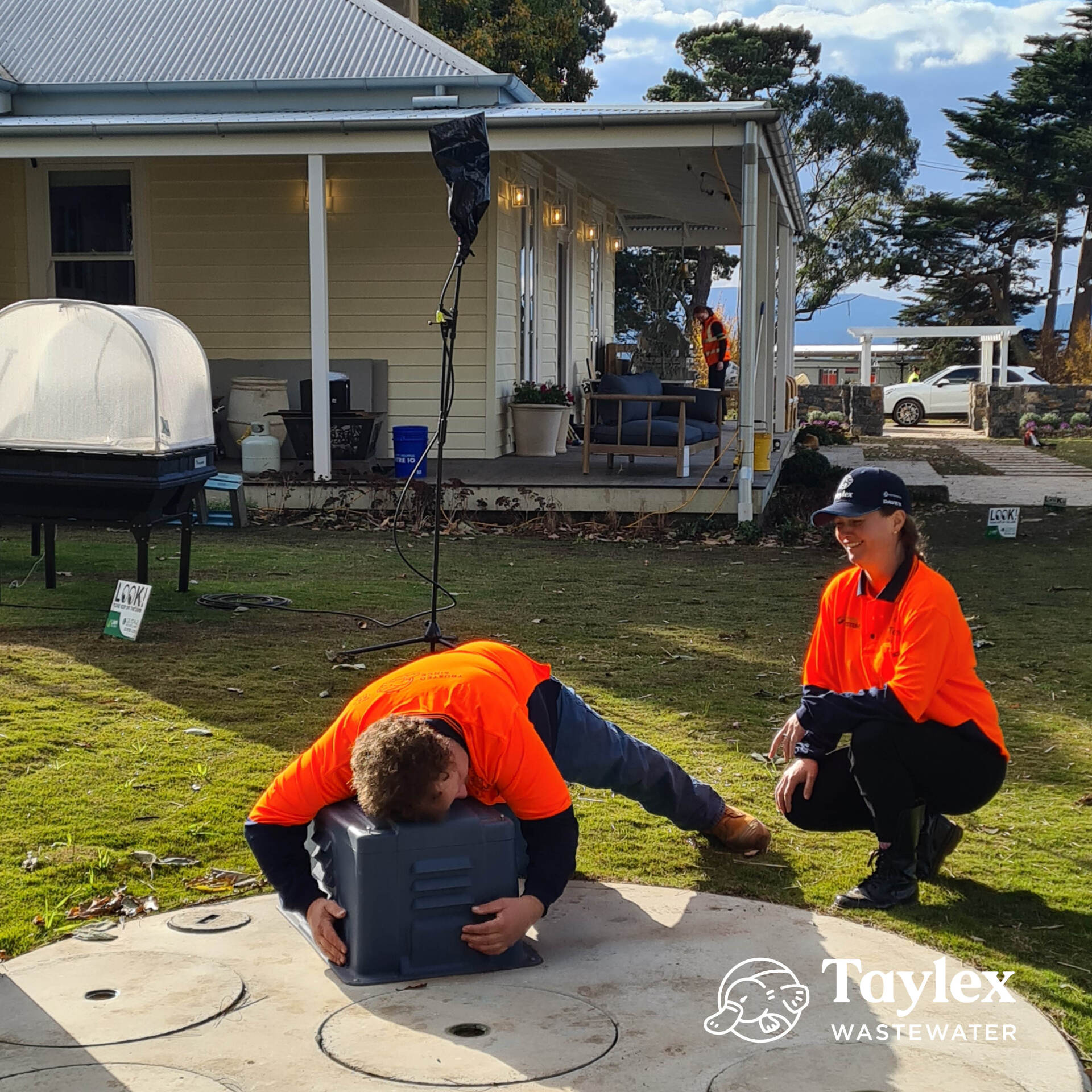 A Man in an Orange Shirt is Laying on the Ground — Mid Richmond Plumbers & Suppliers in Coraki, NSW