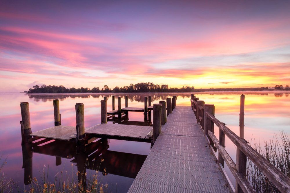There Is a Dock in The Middle of A Lake at Sunset — Mid Richmond Plumbers & Suppliers in Grafton, NSW