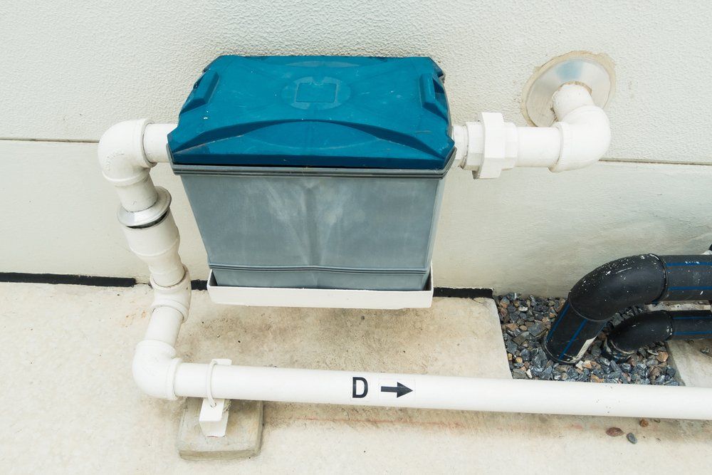 A Blue Box is Attached to a White Pipe on the Side of a Building — Mid Richmond Plumbers & Suppliers in Coraki, NSW