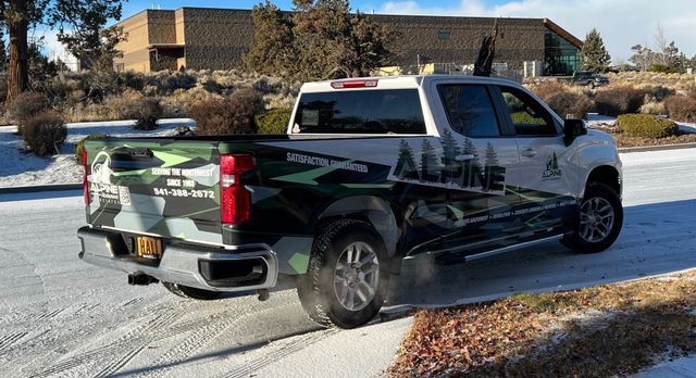 A white truck is driving down a snowy road.
