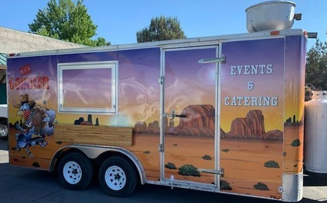 A trailer that says events and catering is parked in a parking lot.
