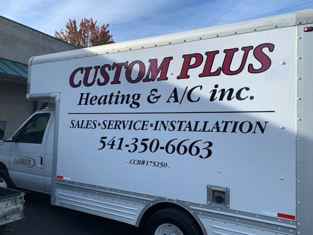 A white truck that says custom plus heating and a/c inc.