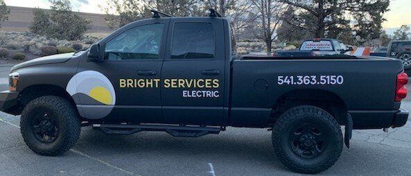 A black truck is parked in a parking lot.