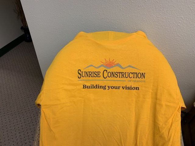 A yellow shirt that says sunrise construction on it
