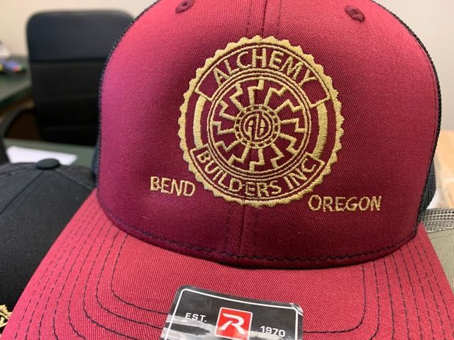 A red hat with the word alchemy on it