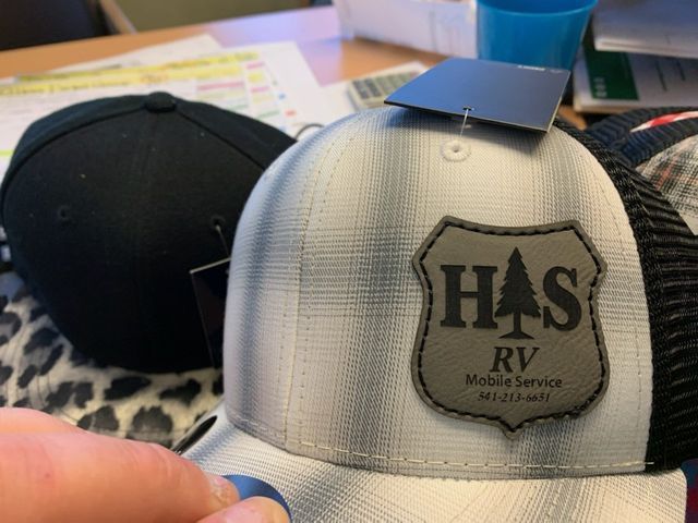 A person is holding a hat that says has rv mobile service