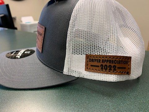 A hat with a leather patch on it is sitting on a table.