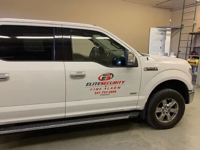 A white truck with the word elite security on the side