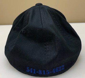 The back of a black baseball cap with a phone number embroidered on it.