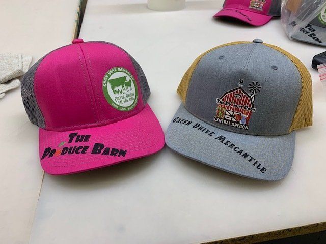 Two hats on a table with one that says the product barn