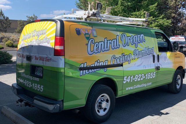 A green and yellow van is parked on the side of the road.
