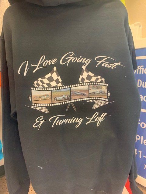 A black hoodie that says i love going fast and turning left
