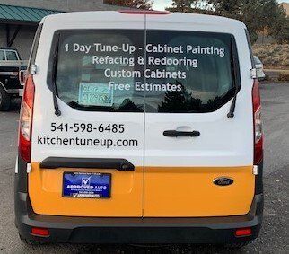 A white and yellow van is parked in a parking lot.