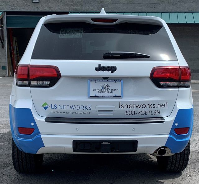 A white and blue jeep with lsnetworks.net written on the back