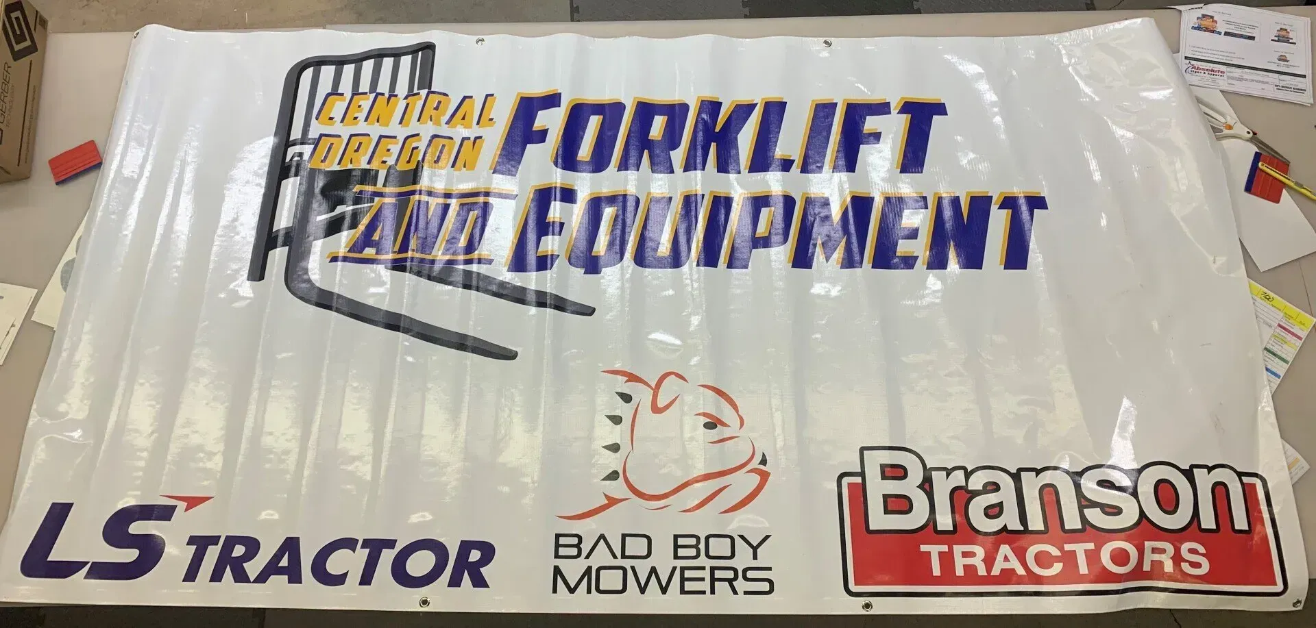 A forklift equipment sign that says ls tractor bad boy mowers and branson tractors