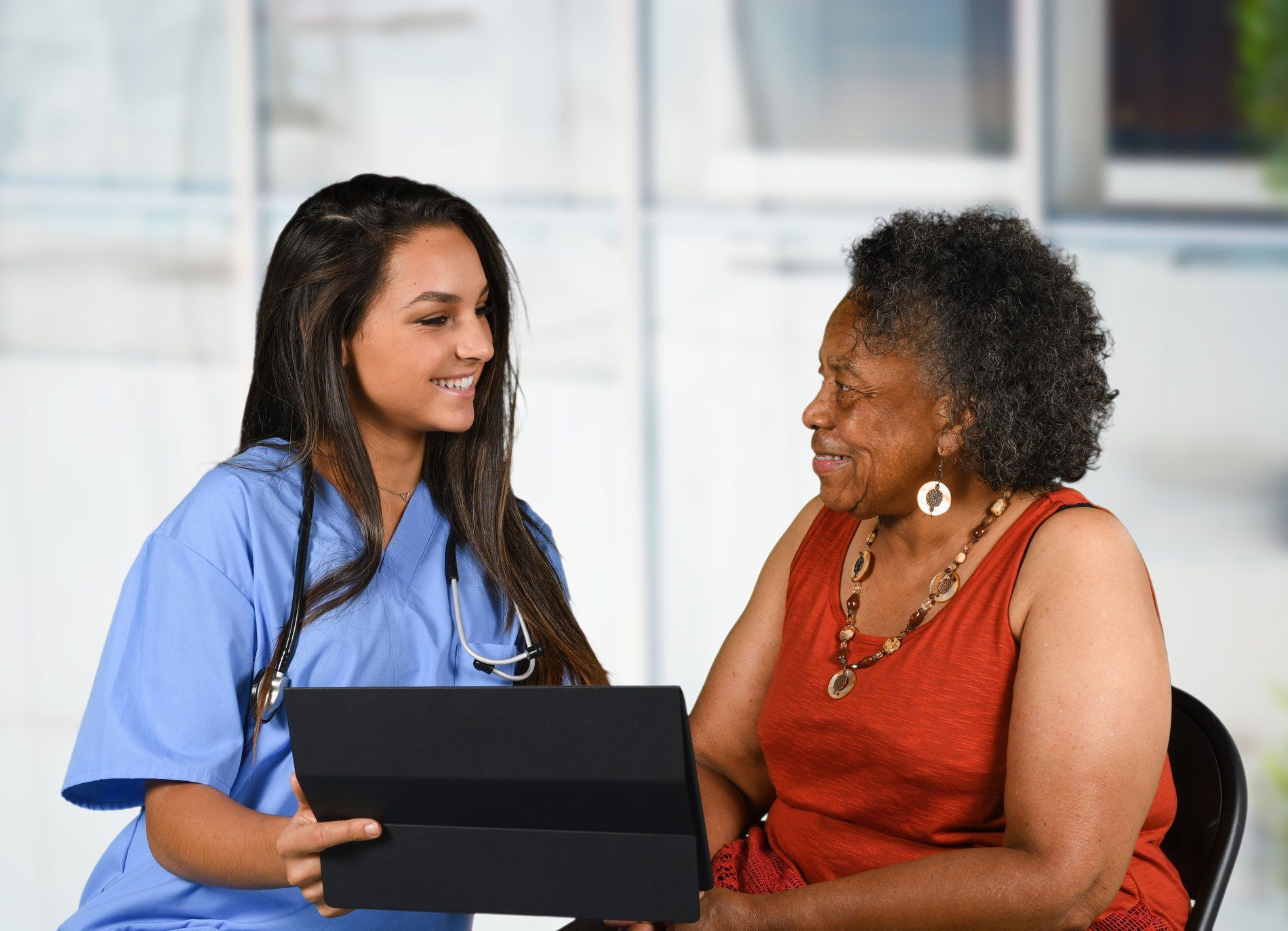 Nurse Viewing Tablet To Old Woman - Saint Louis, MO - Mediplex Community Hospice