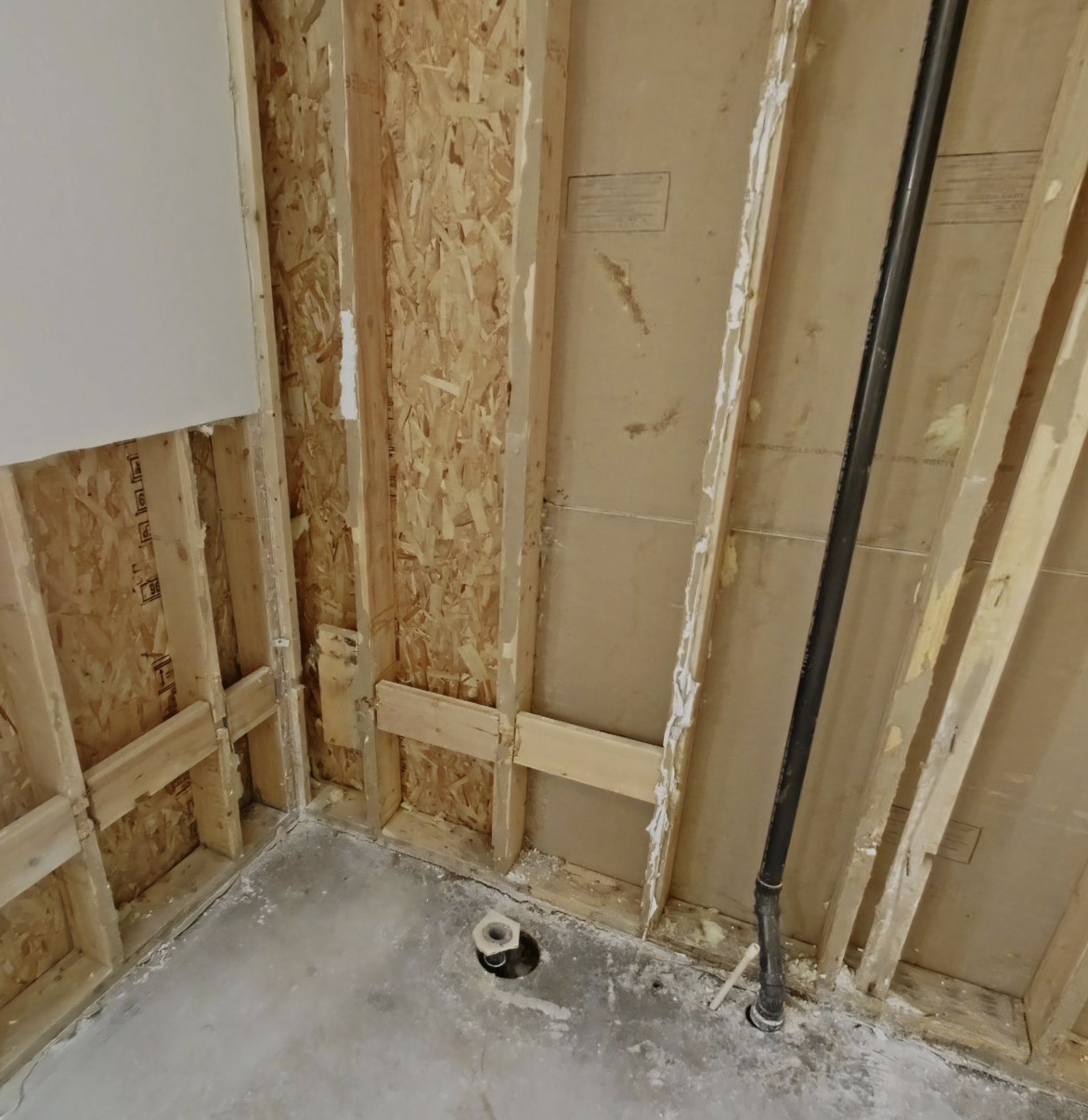 Exposed bathroom framing after water damage