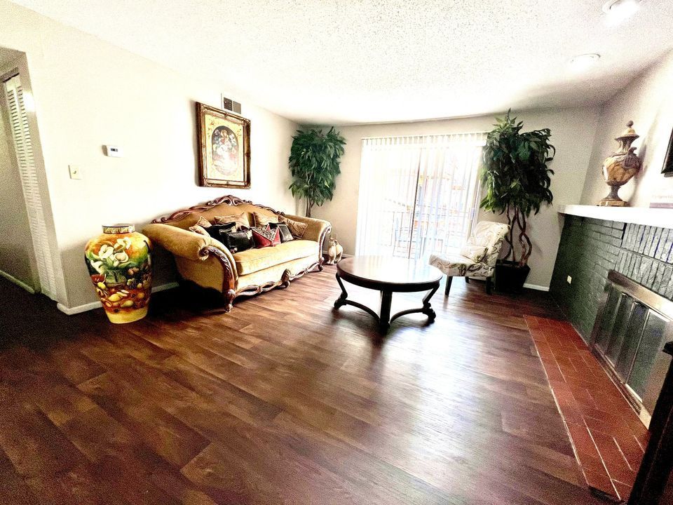 Living room with ornate furniture, hardwood floors, and a decorative fireplace.