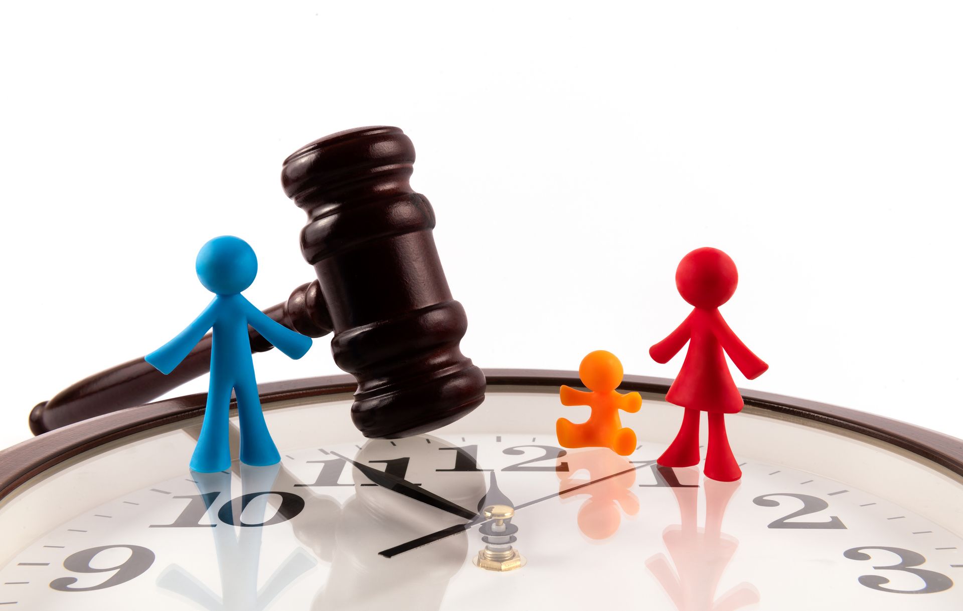 Figurines of a family with one child and a judge’s gavel on a clean white background. Figurines of a family with one child and a judge’s gavel on a clean white background.
