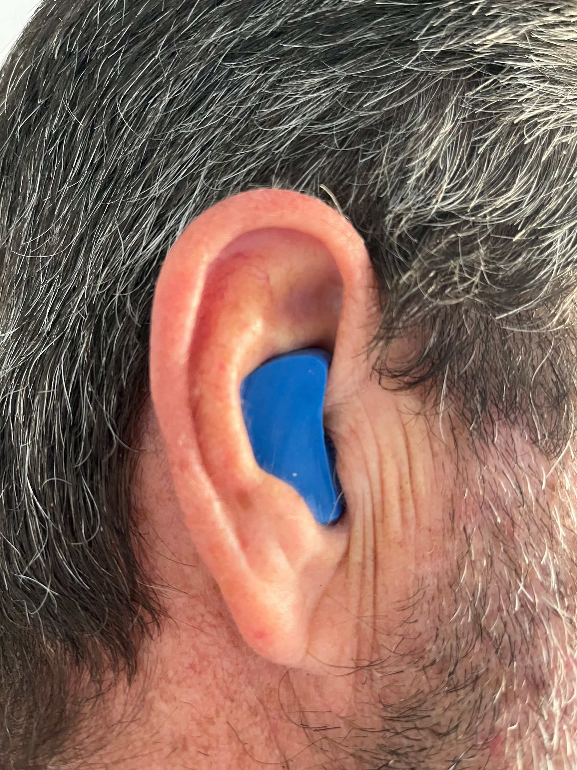 A Close Up of a mans 's Ear With a Hearing Aid in It — Clayton Hearing in Pialba, QLD
