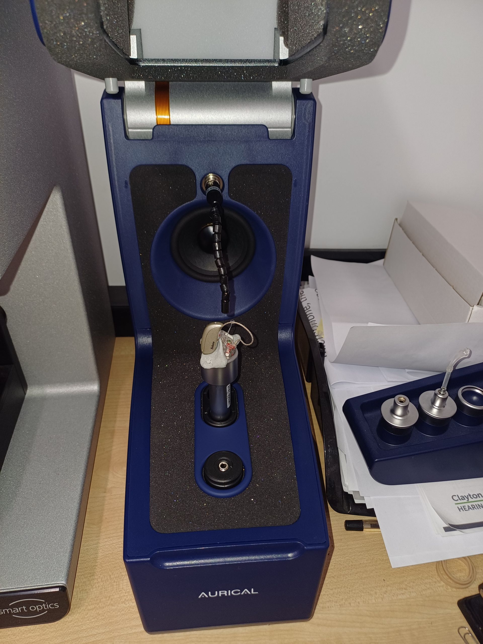 A Person is Fixing a Hearing Aid With Tweezers — Clayton Hearing in Pialba, QLD