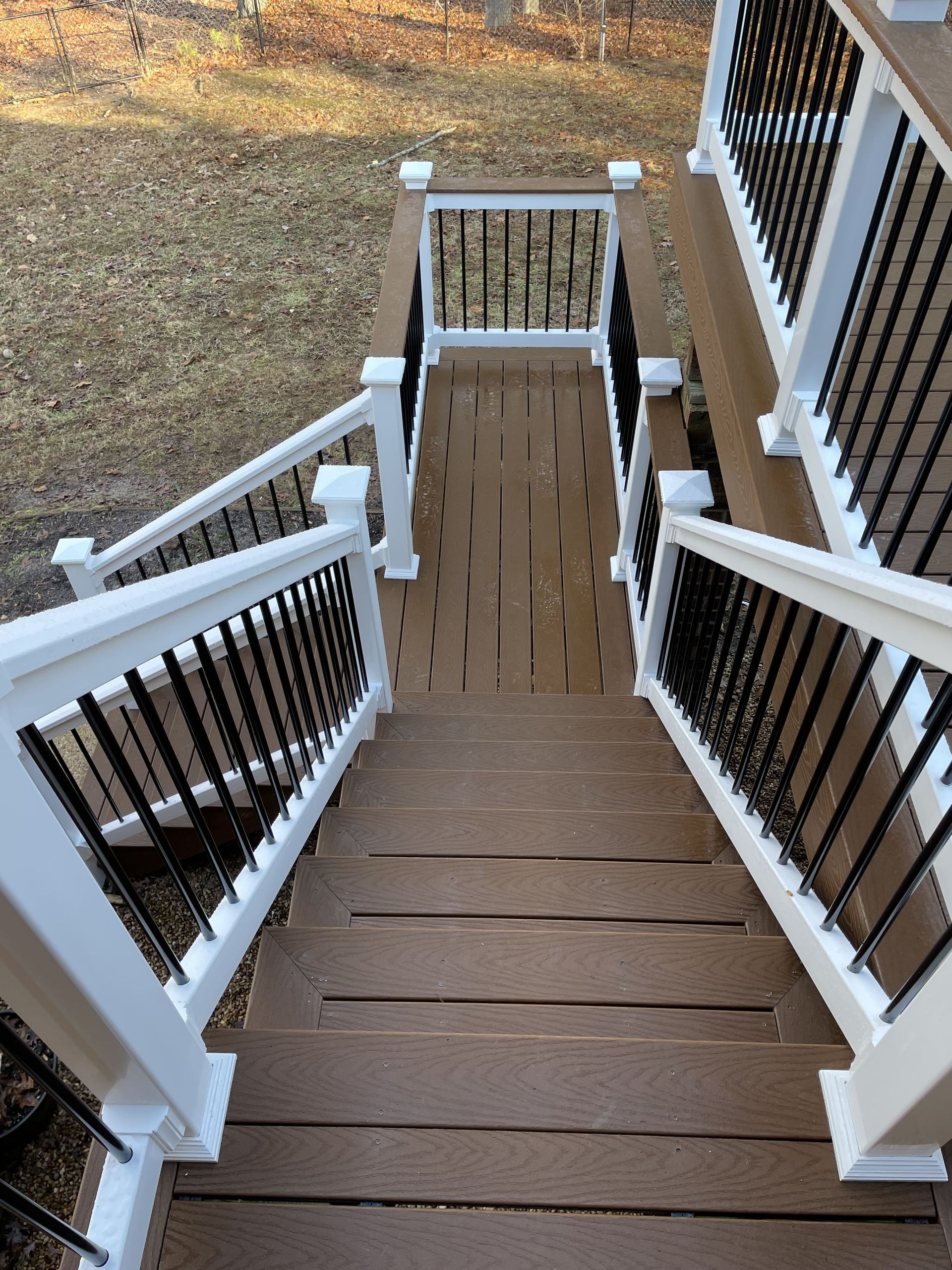 A wooden deck with stairs and a white railing